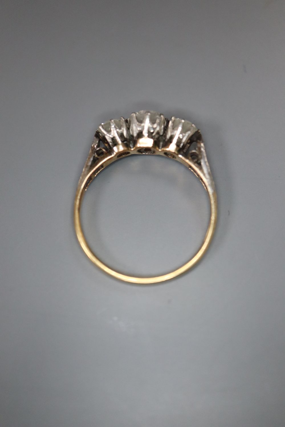 A mid 20th century 18ct and plat three stone diamond ring, with diamond set shoulders, size K/L, gross 2.4 grams.